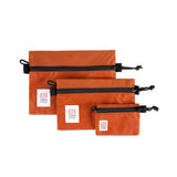 Topo Designs Accessory Bags- product shot of the medium, small, and micro accessory bags in clay orange